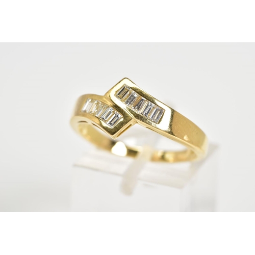 23 - AN 18CT GOLD DIAMOND RING, of crossover design set with ten baguette/tapered baguette cut diamonds t... 