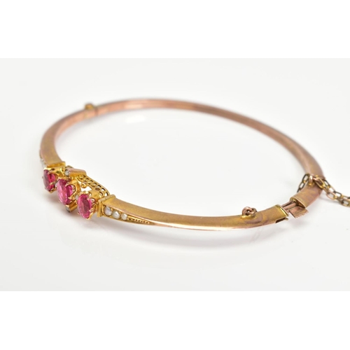 3 - AN EARLY 20TH CENTURY GOLD SPLIT PEARL AND GARNET TOPPED DOUBLET FANCY BANGLE, measuring approximate... 