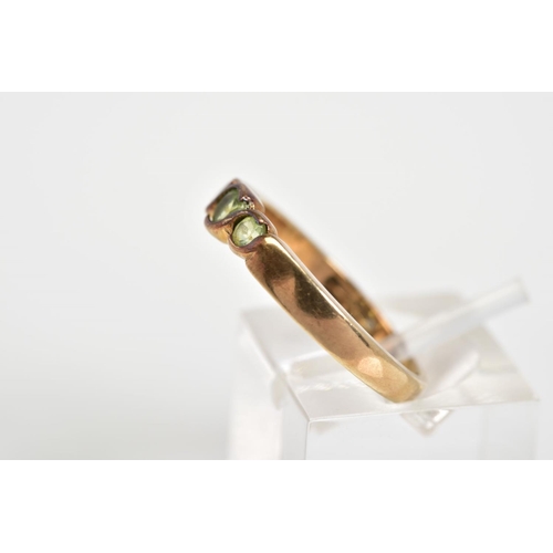 48 - A 9CT GOLD THREE STONE RING, set with three circular cut peridots within a cross over mount, to the ... 