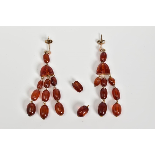 58 - A PAIR OF AMBER MULTI DROP EARRINGS, each designed with post and scroll fittings suspending an oval ... 