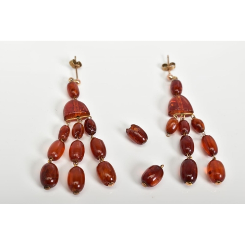 58 - A PAIR OF AMBER MULTI DROP EARRINGS, each designed with post and scroll fittings suspending an oval ... 