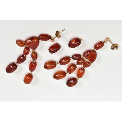 58 - A PAIR OF AMBER MULTI DROP EARRINGS, each designed with post and scroll fittings suspending an oval ... 