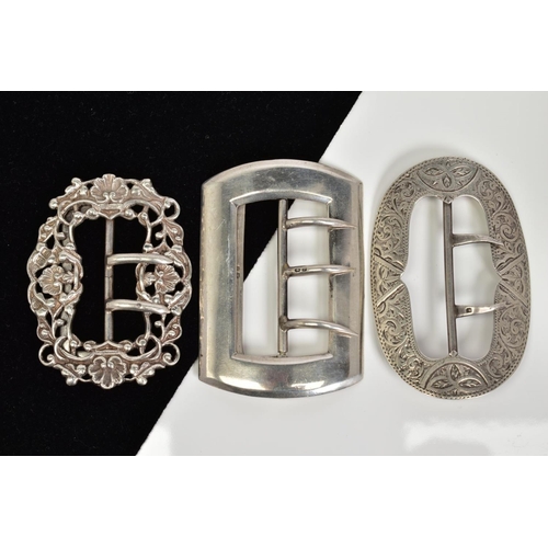 63 - THREE SILVER BELT BUCKLES, the first of oval shape with floral engraved detail, Birmingham hallmark,... 