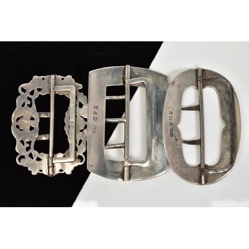 63 - THREE SILVER BELT BUCKLES, the first of oval shape with floral engraved detail, Birmingham hallmark,... 