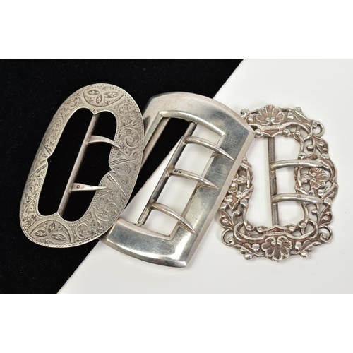 63 - THREE SILVER BELT BUCKLES, the first of oval shape with floral engraved detail, Birmingham hallmark,... 