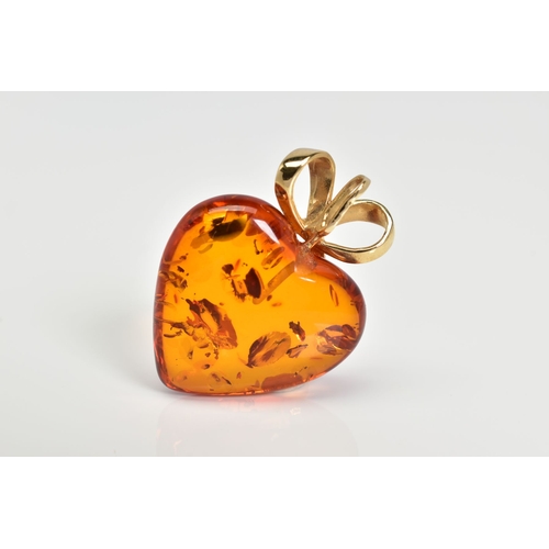 3 - A MODERN 14CT GOLD AMBER HEART PENDANT, measuring approximately 23mm in diameter, fancy bow pendant ... 