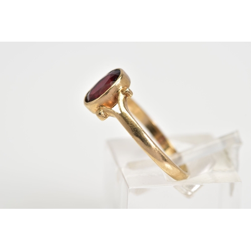 50 - A 9CT GOLD GARNET RING, set with a central oval cut garnet to the bifurcated shoulders and plain pol... 