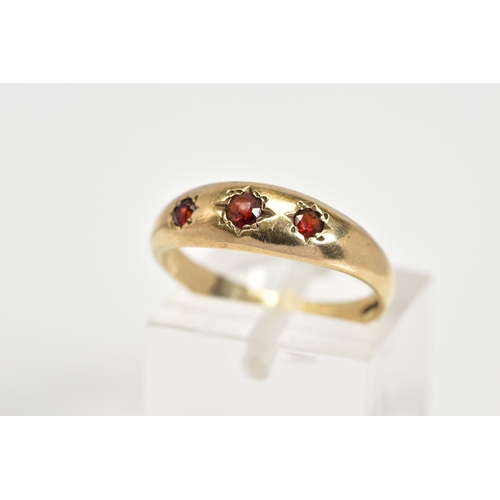 51 - A 9CT GOLD THREE STONE RING, set with three graduated circular cut garnets within a plain polished b... 