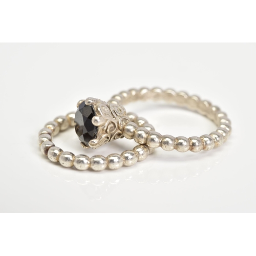 54 - TWO PANDORA RINGS, the first set with a circular cut onyx within a six claw setting, with scrolling ... 