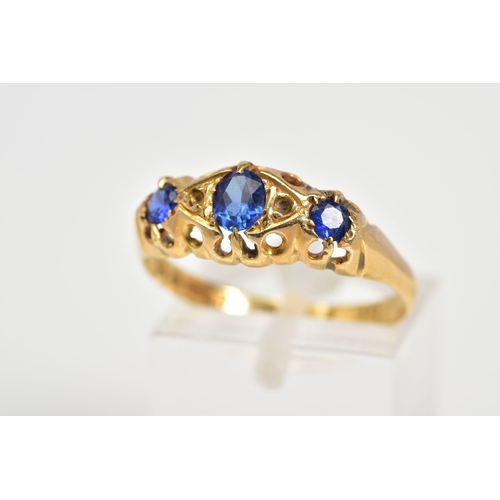 57 - AN EARLY 20TH CENTURY BOAT RING, set with three graduated oval cut, assessed as synthetic sapphire, ... 