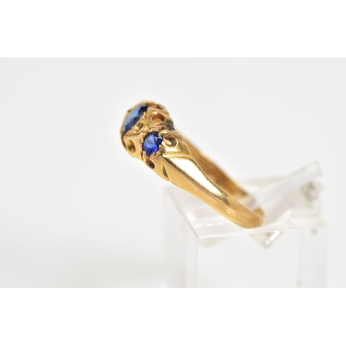 57 - AN EARLY 20TH CENTURY BOAT RING, set with three graduated oval cut, assessed as synthetic sapphire, ... 