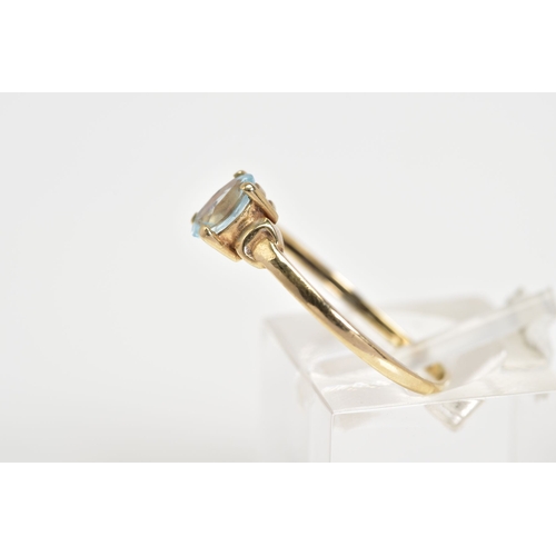 60 - A SINGLE STONE RING, set with a central oval cut aquamarine within a four claw setting, to the plain... 