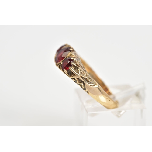 68 - A 9CT GOLD BOAT RING, set with three graduated circular garnets within a scrolling detail gallery, w... 