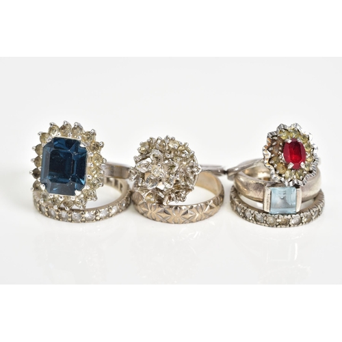 79 - A SELECTION OF WHITE METAL RINGS, to include three coloured stone set cluster rings, two colourless ... 