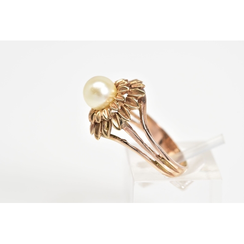 83 - A PEARL RING, designed with a central single cultured pearl within a tiered floral surround, to the ... 