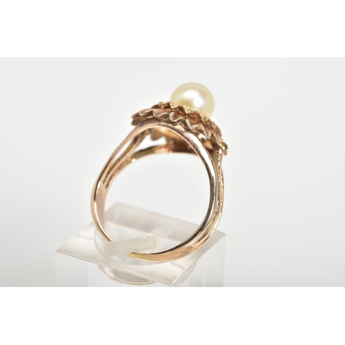 83 - A PEARL RING, designed with a central single cultured pearl within a tiered floral surround, to the ... 