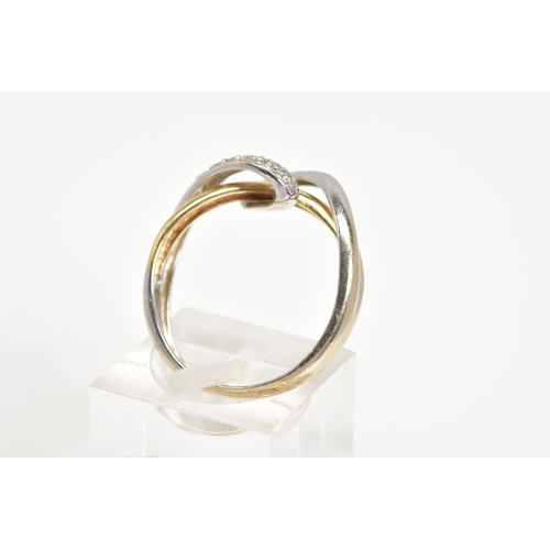 91 - A DIAMOND SET CROSSOVER RING, of white and yellow metal open work crossover style, set with a diagon... 