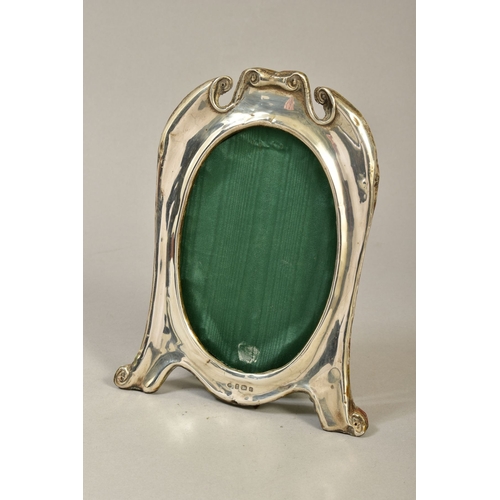 106 - AN EDWARDIAN SILVER PHOTOGRAPH FRAME OF CARTOUCHE SHAPE, with oval aperture, easel back, maker Willi... 