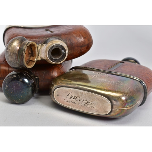 181 - A SET OF THREE GRADUATED SILVER AND CROCODILE SKIN GLASS HIP FLASKS with quarter turn caps