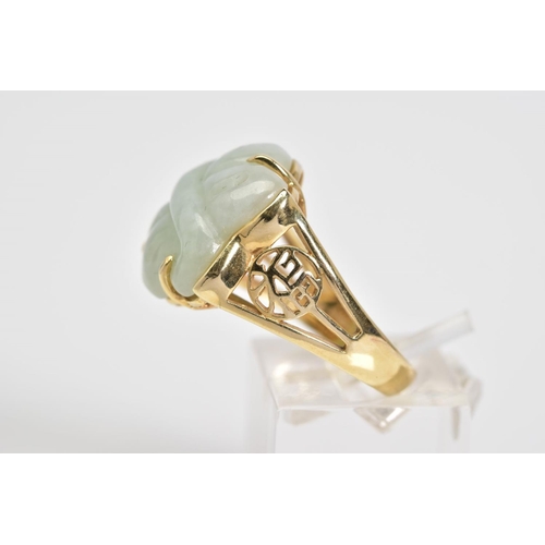 1 - A 14CT GOLD JADE RING, a carved jade panel set within a four claw setting, with Oriental design open... 