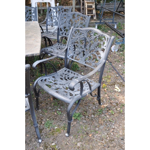 1011 - A LARGE STONE EFFECT GARDEN TABLE AND EIGHT CHAIRS, with real stone veneers in a crazy paving effect... 