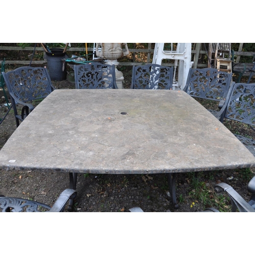 1011 - A LARGE STONE EFFECT GARDEN TABLE AND EIGHT CHAIRS, with real stone veneers in a crazy paving effect... 