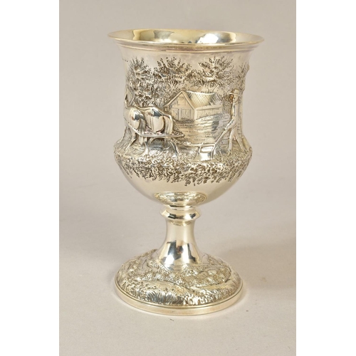 105 - A VICTORIAN SILVER CUP, repousse decorated with a rural scene of two men and horses ploughing, engra... 