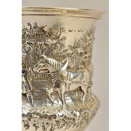 105 - A VICTORIAN SILVER CUP, repousse decorated with a rural scene of two men and horses ploughing, engra... 