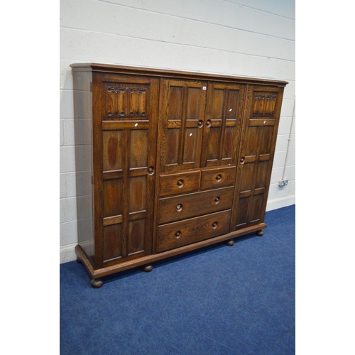 1202 - AN EARLY TO MID 20TH CENTURY LOW SOLID OAK COMPACTUM WARDROBE, comprising two panelled doors with li... 