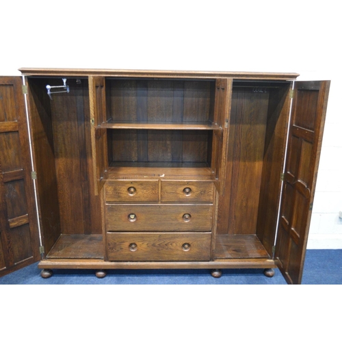 1202 - AN EARLY TO MID 20TH CENTURY LOW SOLID OAK COMPACTUM WARDROBE, comprising two panelled doors with li... 