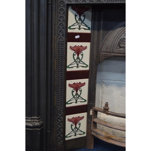 1215 - A VICTORIAN STYLE CAST IRON FIRE SURROUND and insert with Art Nouveau burgundy, green and white grou... 