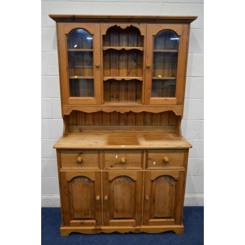 1218 - A MODERN PINE KITCHEN DRESSER, to top section with double glazed cupboard doors above a base with th... 