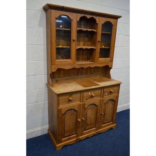 1218 - A MODERN PINE KITCHEN DRESSER, to top section with double glazed cupboard doors above a base with th... 