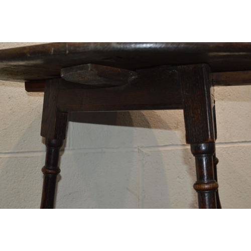 1221 - AN 18TH CENTURY CIRCULAR OAK PLANK TOP CRICKET TABLE, with joint splayed turned legs, united by stre... 