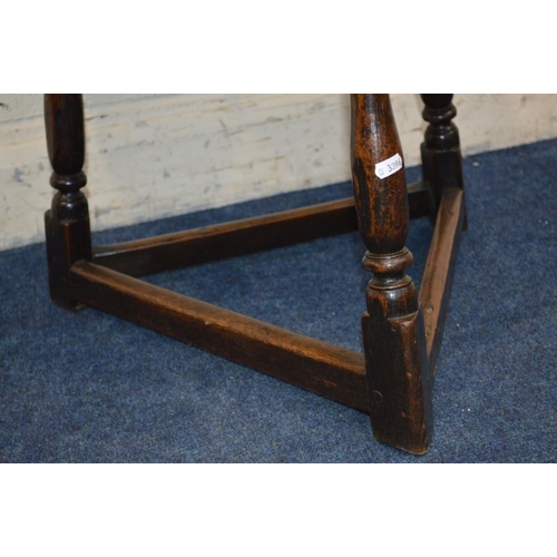 1221 - AN 18TH CENTURY CIRCULAR OAK PLANK TOP CRICKET TABLE, with joint splayed turned legs, united by stre... 