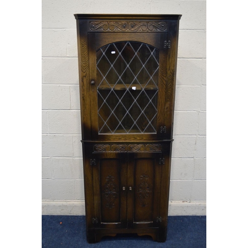 1237 - A REPRODUCTION OAK LEAD GLAZED SINGLE DOOR CORNER CUPBOARD, above double cupboard doors, approximate... 