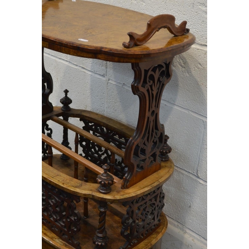 1248 - A LATE VICTORIAN BURR WALNUT CANTERBURY, shaped oval top with handles, on foliate scrolling end supp... 