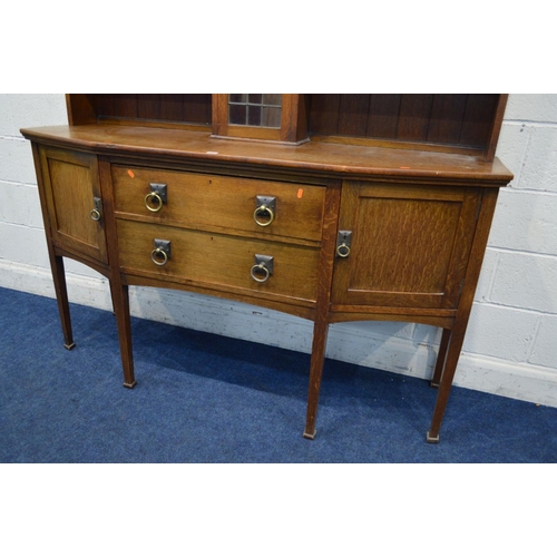 1251 - AN EARLY 20TH CENTURY OAK ARTS & CRAFTS SIDEBOARD, the top with shelves flanking a single lead glaze... 