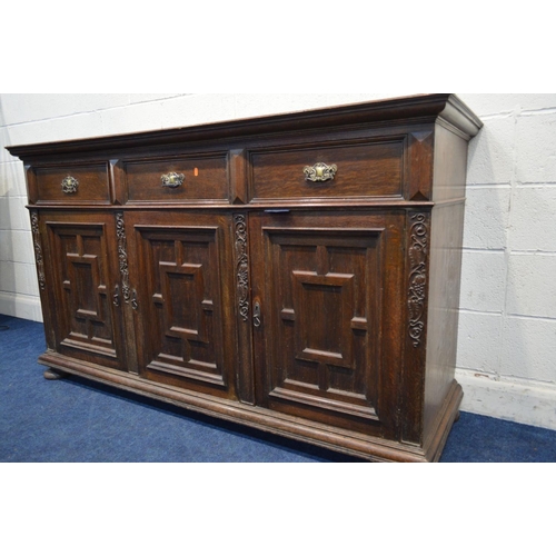 1259 - AN EARLY 20TH CENTURY OAK SIDEBOARD, with three drawers, above three geometric panelled doors, width... 