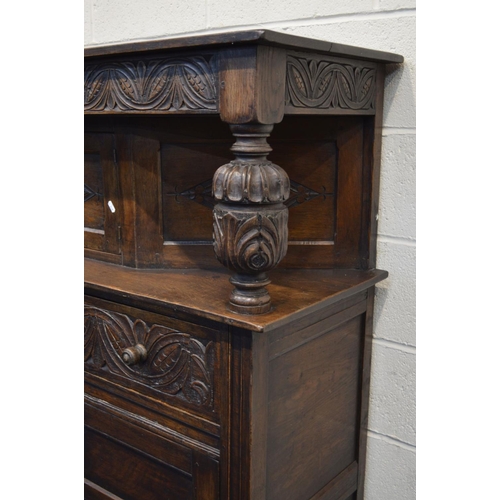 1304 - AN EARLY TO MID 20TH CENTURY CARVED OAK COURT CUPBOARD, the overhanging top flanking with acorn supp... 