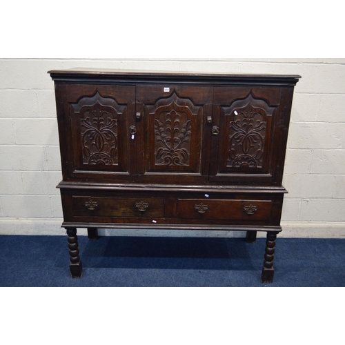 1310 - AN 18TH CENTURY AND LATER CARVED OAK TWO DOOR DEUDDARN, carved triple panel front, above two drawers... 