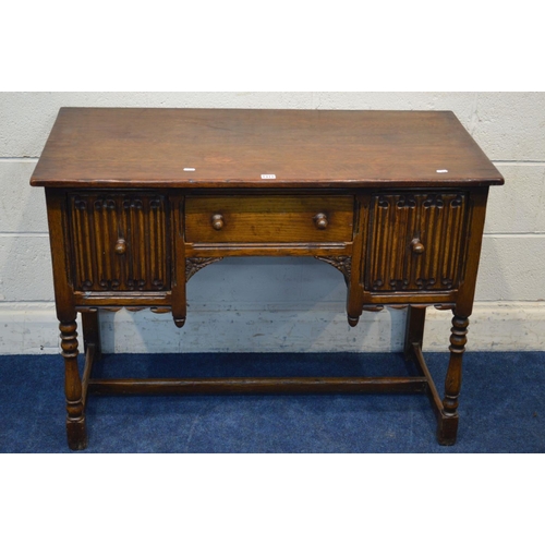 1311 - A REPRODUCTION OAK DESK, with two deep linenfold front drawers flanking a single drawer, on turned f... 