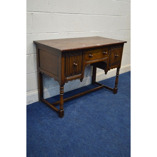 1311 - A REPRODUCTION OAK DESK, with two deep linenfold front drawers flanking a single drawer, on turned f... 