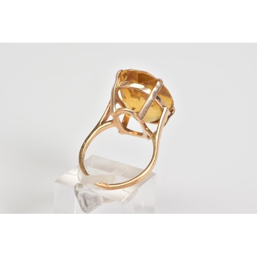 2 - A LARGE CITRINE RING, set with a large oval cut citrine within a raised four claw setting, to the pl... 