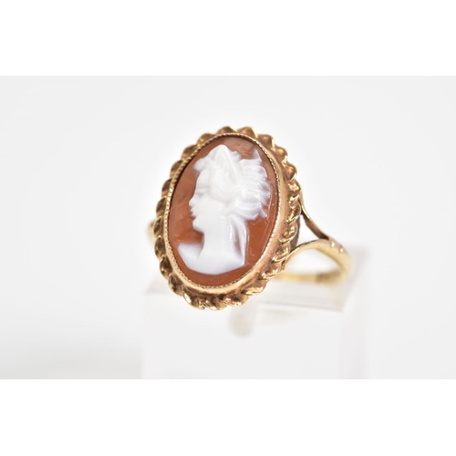 25 - A 9CT GOLD CAMEO RING, of oval design depicting a lady in profile with a rope twist surround, to the... 