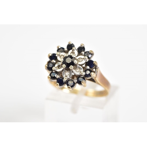 27 - A 9CT GOLD CLUSTER RING, a three tiered cluster design set with a central circular cut sapphire, sin... 