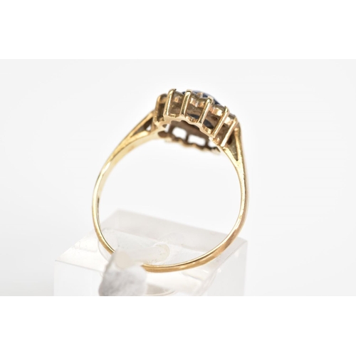 28 - A 9CT GOLD CLUSTER RING, set with a central oval cut sapphire with a cut cubic zirconia surround, to... 