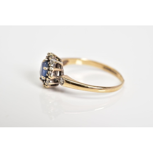 36 - A 9CT GOLD CLUSTER RING, set with a central oval cut sapphire, single cut diamond surround to the di... 