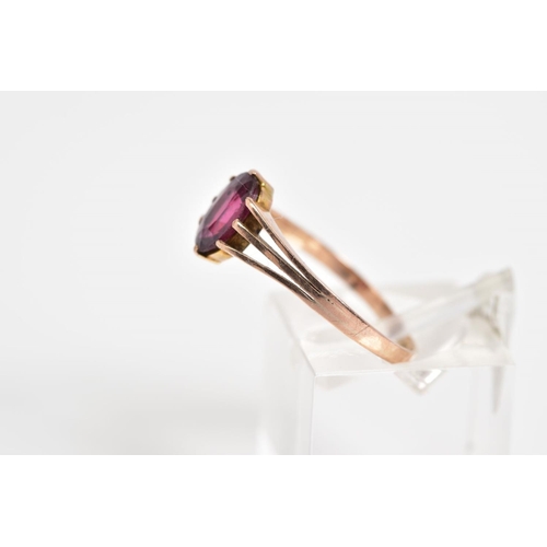 40 - A 9CT GOLD GARNET RING, set with an oval cut garnet to the trifurcated shoulders and plain polished ... 