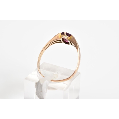 40 - A 9CT GOLD GARNET RING, set with an oval cut garnet to the trifurcated shoulders and plain polished ... 